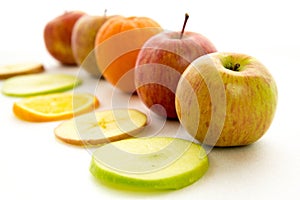 Line of apples and slices with one orange