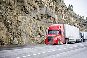 Line of big rig semi trucks stopped at a mountain pass in California to cool an overheated engine before a long highway descent