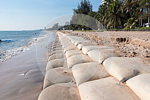 Line big sandbag prevent waves at Cha Am beach of Thailand.