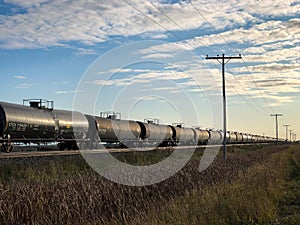 Line of Black Tank Train Cars Under Blue Sky