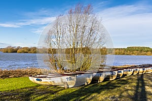 A line of  boats on the shoreline of Pitsford Reservoir, UK