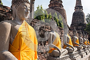 Line of Buddha statues in Wat Yai Chai Mongkol temple. Ayutthaya Historical Park, Thailand. UNESCO World Heritage Site.