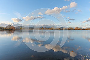 Line of clouds reflecting in a flooded meadow after heavy rains. Autumn landscape