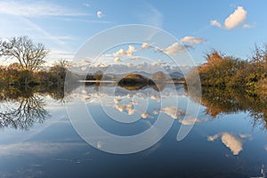 Line of clouds reflecting in a flooded meadow after heavy rains. Autumn landscape