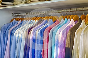 Line of Colorful Linen Summer long Sleeve Shirts Placed on Hangers in Store of Oia Village in Santorini Island in Greece