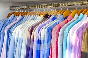 Line of Colorful Linen Summer long Sleeve Shirts Placed on Hangers in Store of Oia Village in Santorini Island in Greece