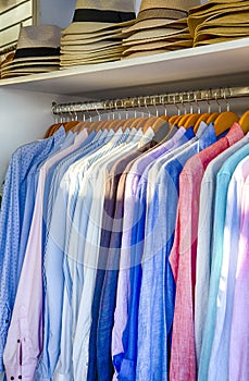 Line of Colorful Linen Summer long Sleeve Shirts Placed on Hangers in Store of Oia Village in Santorini Island in Greece