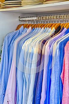 Line of Colorful Linen Summer long Sleeve Shirts Placed on Hangers in Store of Oia Village in Santorini Island in Greece