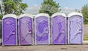 Line of Five Purple Color Event Porta Potty Toilets