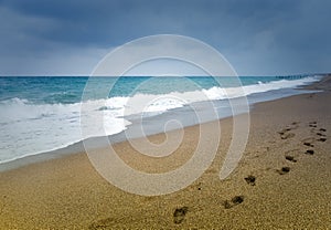 Line of footprints in the sand on a beach