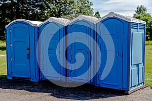 Line of Four Blue Portable Toilets