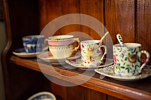 Line of four cups on the wooden shelf in a vintage shop in Bruges, Belgium