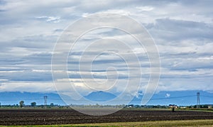 Line of high-voltage electric poles against the backdrop of fields