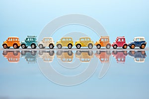 line of identical unbranded toy cars on bright surface