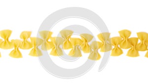 Line made of dry farfalle pasta over isolated white background