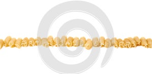 Line made of dry rotini pasta over isolated white background