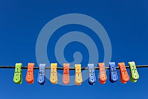 Line of multicolor plastic clothes pegs