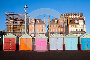 A line of 7 multicoloured beach huts on Brighton promenade in t