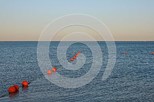 Line of orange buoys at sea