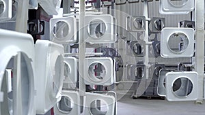 line for painting metal products in white color coating. Square metal products with a round hole hang on mounts after