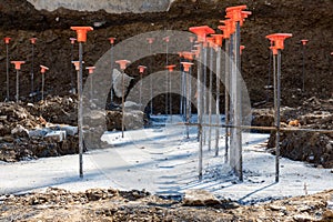 Line of rebar steel rods in poured concrete footings