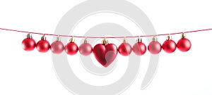 Line of red christmas balls and one heart shape christmas bauble on white background. Christmas decorations.