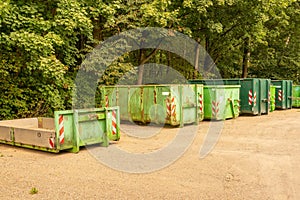 Line of rusty containers near the green trees