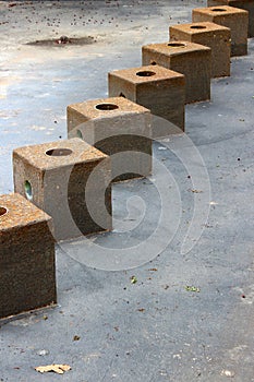 Line of several heavy stone cubes used in water fountain not yet working in warmer weather