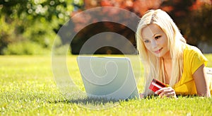 On-line Shopping. Smiling Blonde Girl with Laptop, Credit Card