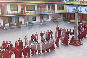 Line of Tibetan monks in front of Rumtek Monastery for welcoming high level monk near Gangtok. Sikkim, India.