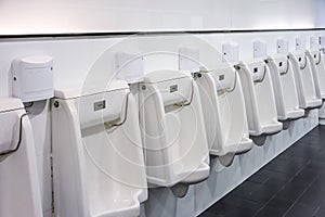 Line of white urinals for men