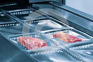 Linear food plastic tray package heat sealing machine. Food industry concept background
