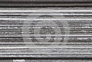 Linear texture of gray asbestos slate plates stacked on top of each other close-up side view