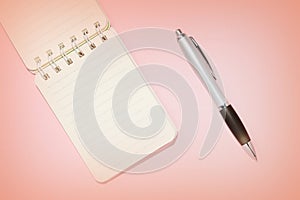 Lined notebook and pen on a pink background close-up. Top view, copy space. Education concept retro style toned