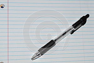 Lined white notebook paper with a black pen