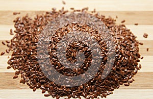 Linen fresh raw seeds lie on a wooden surface. Top view