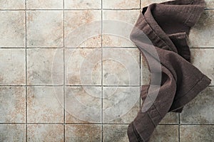 Linen kitchen brawn towel napkin on old ceramic tile table background. Cooking stone backdrop. Top view with copy space. Flat lay