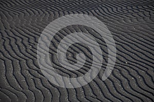 Lines in a black sand beach