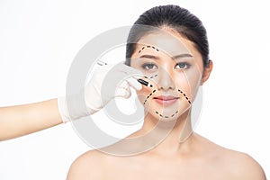 Lines on face, close up, plastic surgery concept, doctor`s hand in glove making marks on patient`s face..Asian beauty  Woman in