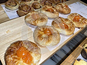 Lines of fresh baked sweet puff pastry stuffed with apricot and peach jelly