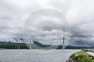 Lines of a suspension bridge on the Kystriksveien route in Norway frame a view shrouded in clouds photo