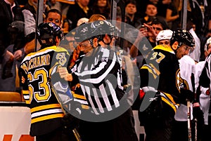 Linesman Bryan Pancich restrains Brad Marchand.