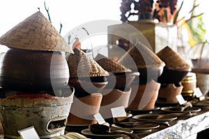 A lineup of traditional clay pot rice warmers, topped with iconic bamboo hats, evoking the warmth and authenticity of Asian