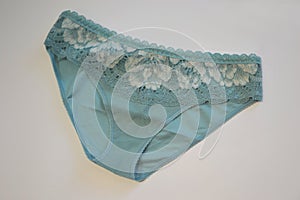 Lingerie. Light blue lace panties on a white background, top view. Fashionable lingerie