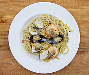 Linguine allo scoglio, dish of italian pasta with seafood on wooden table