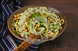 Linguine pasta with  chickpeas and green pesto in a rustic decor