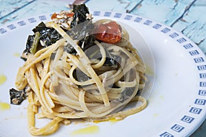 Linguine pasta with fresh anchovies, black cabbage and cherry tomatoes