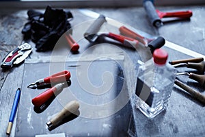 A group of linocut tools on dark table. Lithography concept