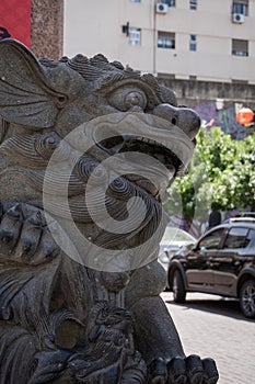 Lion. It guards the entrance arch to Chinatown and a sphere, inside its mouth, symbolizing wisdom photo
