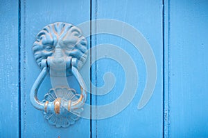 Lion head door knocker on an old wooden door